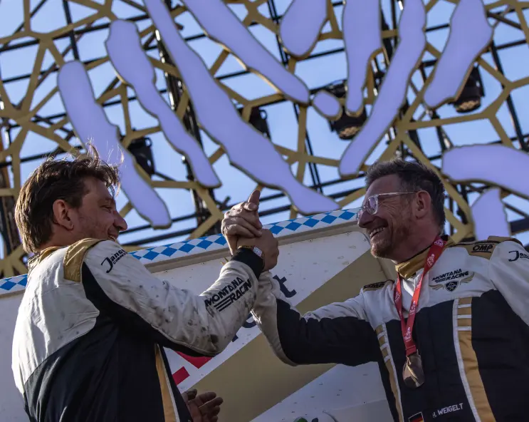 Zwei Rennfahrer schütteln sich die Hände